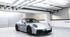 Schwarzer Porsche 911 GT3 RS mit großem Heckspoiler steht in einer weißen Garage.