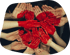 Viele Hände bilden einen Kreis, einige sind mit roter Farbe bemalt und bilden eine Herzform in der Mitte.