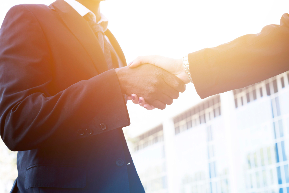 Zwei Personen in Businesskleidung geben sich die Hand