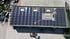Luftaufnahme eines großen Flachdachs mit Solarmodulen und Text "400 kWp PV Leistung, Schwerte".