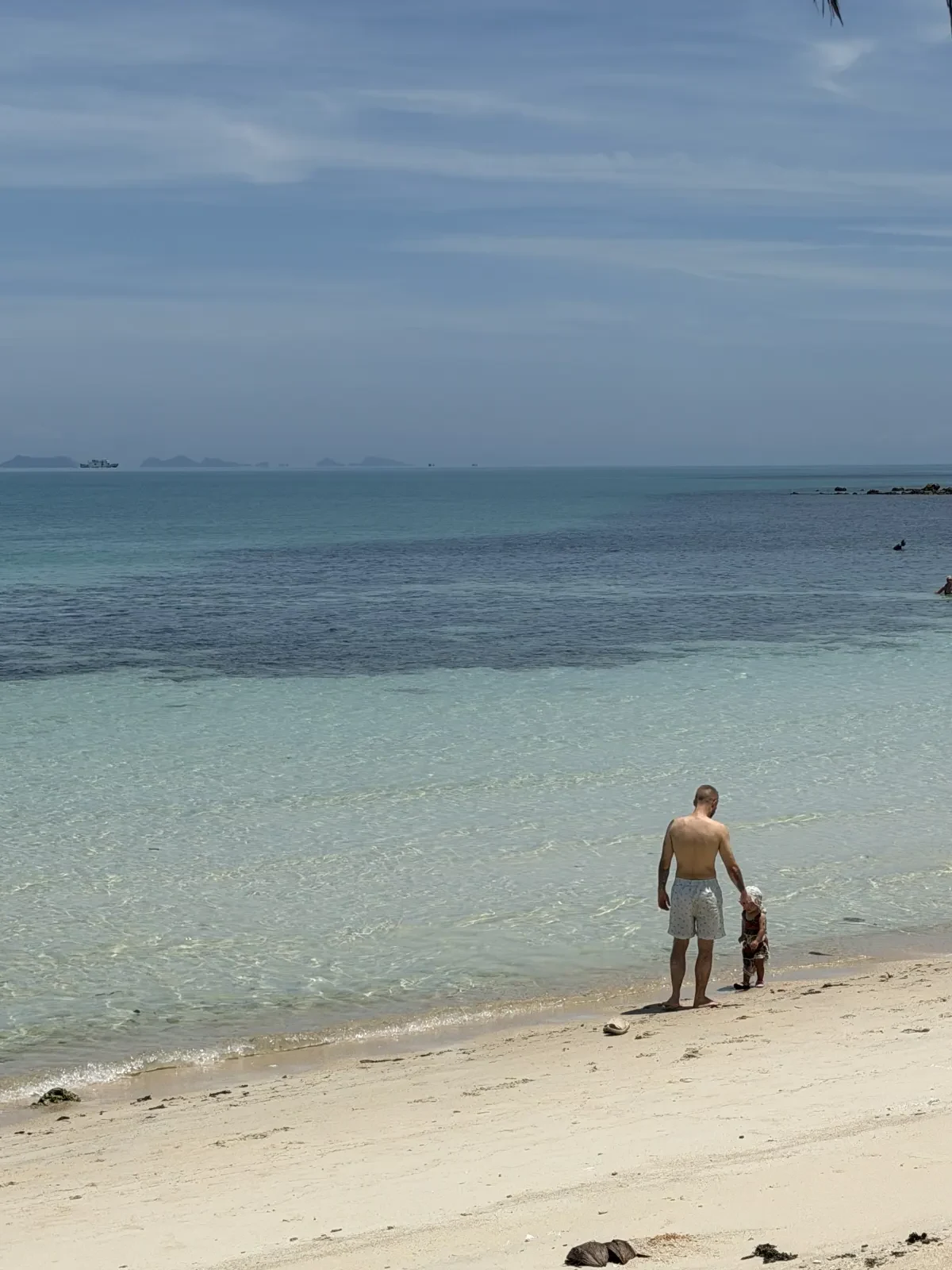 Armin mit einem Kind am Strand und Blick auf das Meer