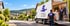 Zwei Möbelpacker beladen einen LKW von Repp Umzüge & Transport in einer Wohnstraße mit Blick auf eine Burg.