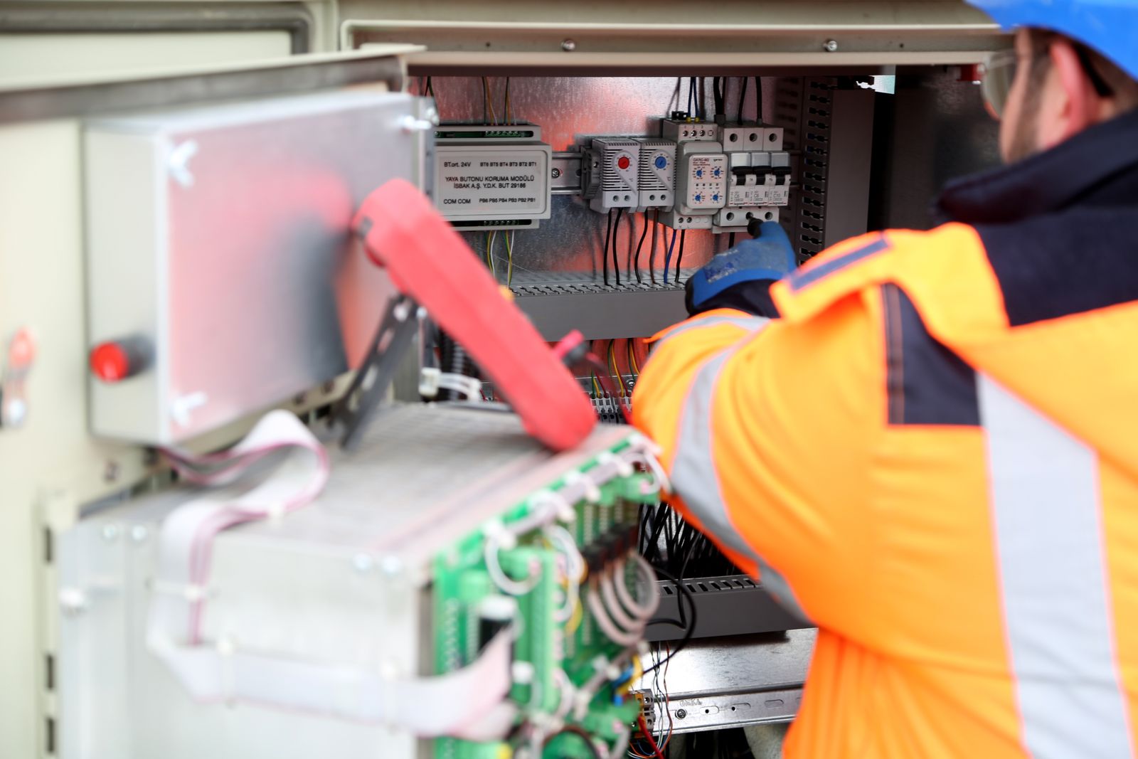 Electrician servicing power electronics on a wall-mounted unit