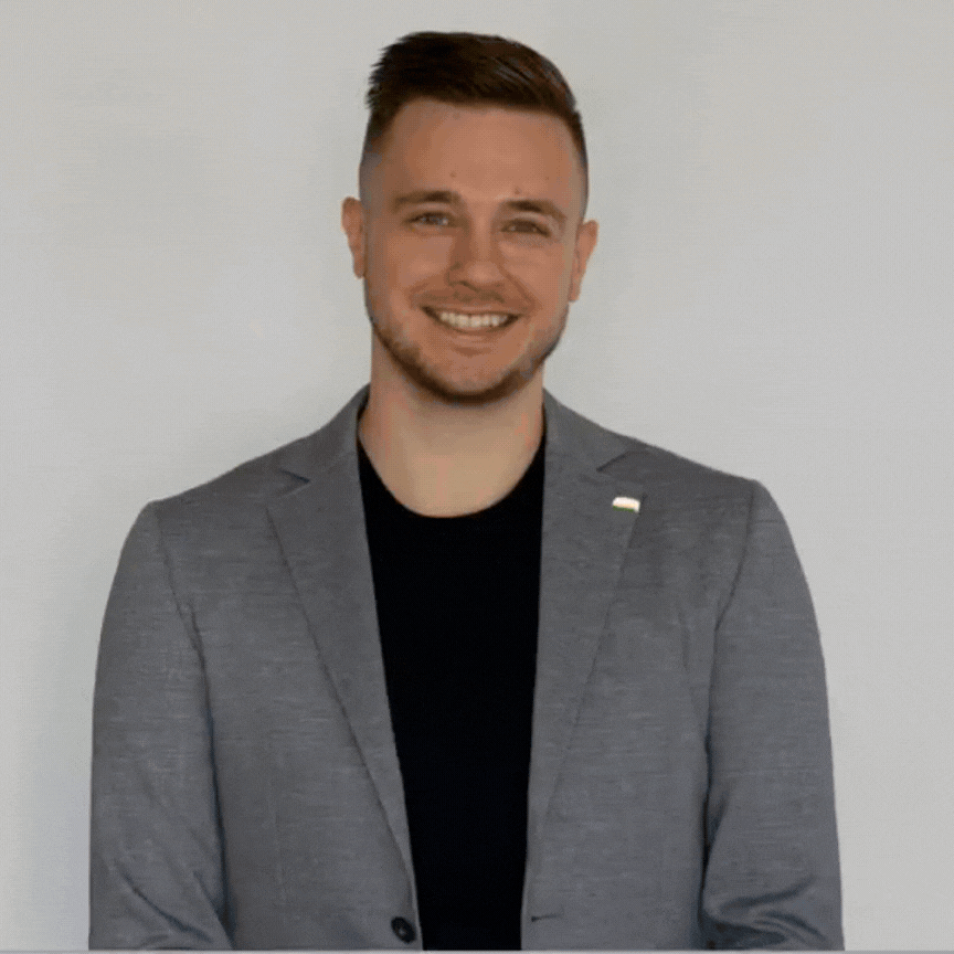 Ein Mann klappt einen Laptop zu und zeigt dabei in die Kamera