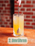 Ein Cocktailglas mit Eis und gelber Flüssigkeit, in dem ein Löffel umrührt, vor einer Ziegelwand. Text: "2. Umrühren."