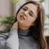 Young woman holding her neck, expressing pain or discomfort after an auto accident.