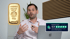 Mann gestikuliert mit Goldbarren "Heraeus Feingold 999.9 100g" und Experten-Score 4,9 von 5 Sternen