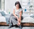 Woman on bed holding ankle, highlighting foot and ankle pain care