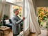 Mann öffnet im Herbst ein großes Fenster weit zum Stoßlüften
