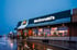 McDonald's Restaurant bei Dämmerung, beleuchtetes Logo, reflektierende nasse Straße.