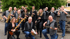 Eine 13-köpfige Jazzband posiert im Freien mit Saxophonen, Trompeten, Posaunen, Gitarren und Schlagzeug.