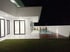 Modernes Haus mit Pool und Rasenfläche bei Nacht; helle Innenräume durch große Fenster sichtbar.