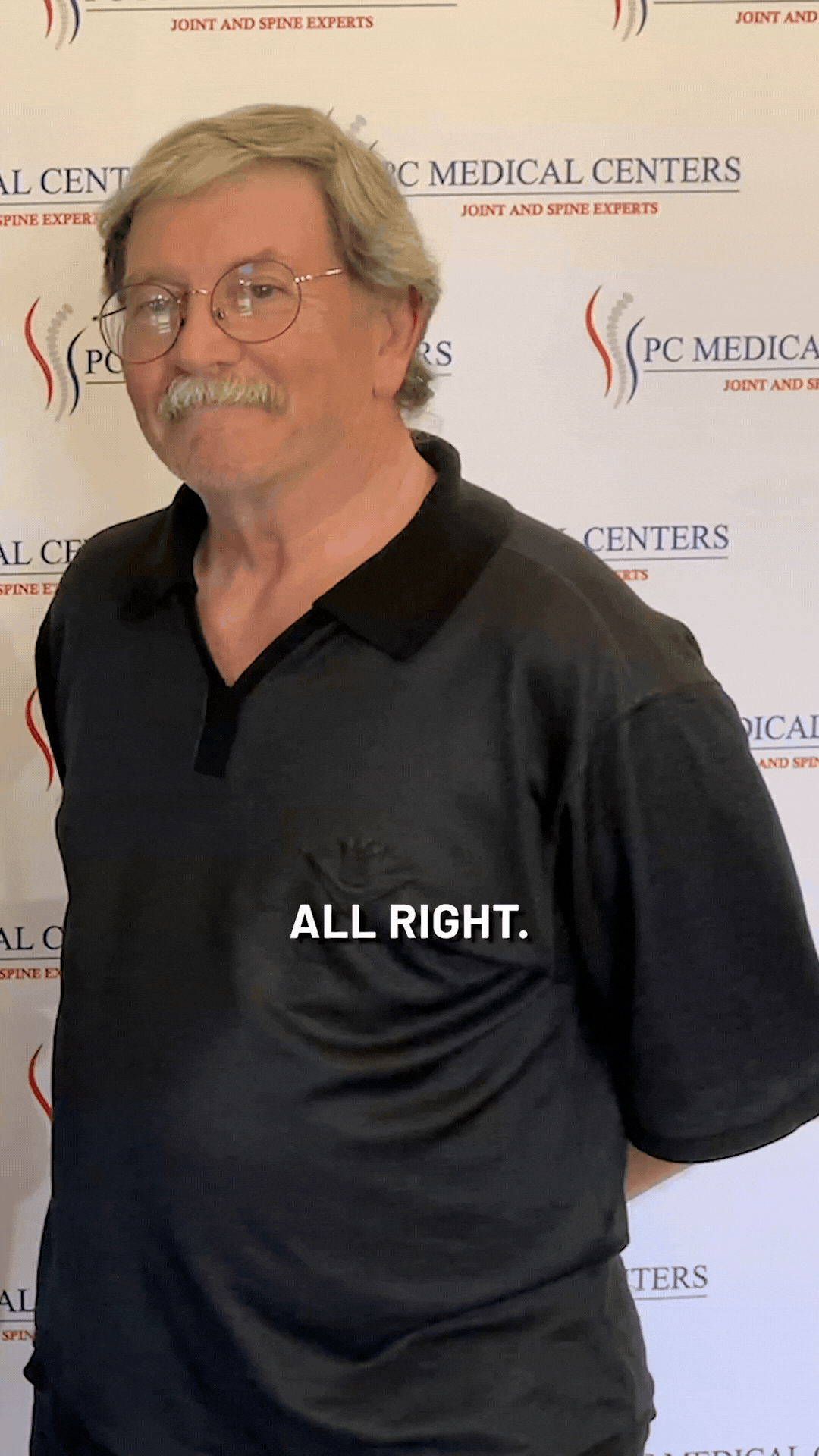 Patient in a black polo shirt sharing his testimonial in front of the PC Medical Centers backdrop
