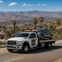 Towing Corona flatbed towing service transporting a disabled sedan safely through Corona, California.