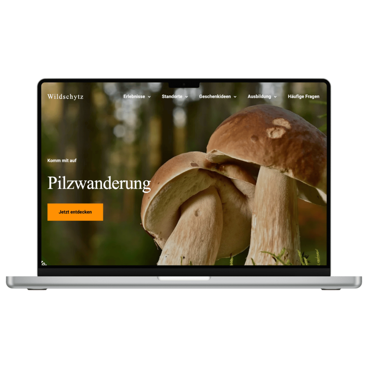 Laptop zeigt die Wildschytz-Website mit dem Titel "Pilzwanderung" und einem Bild von Pilzen im Wald.