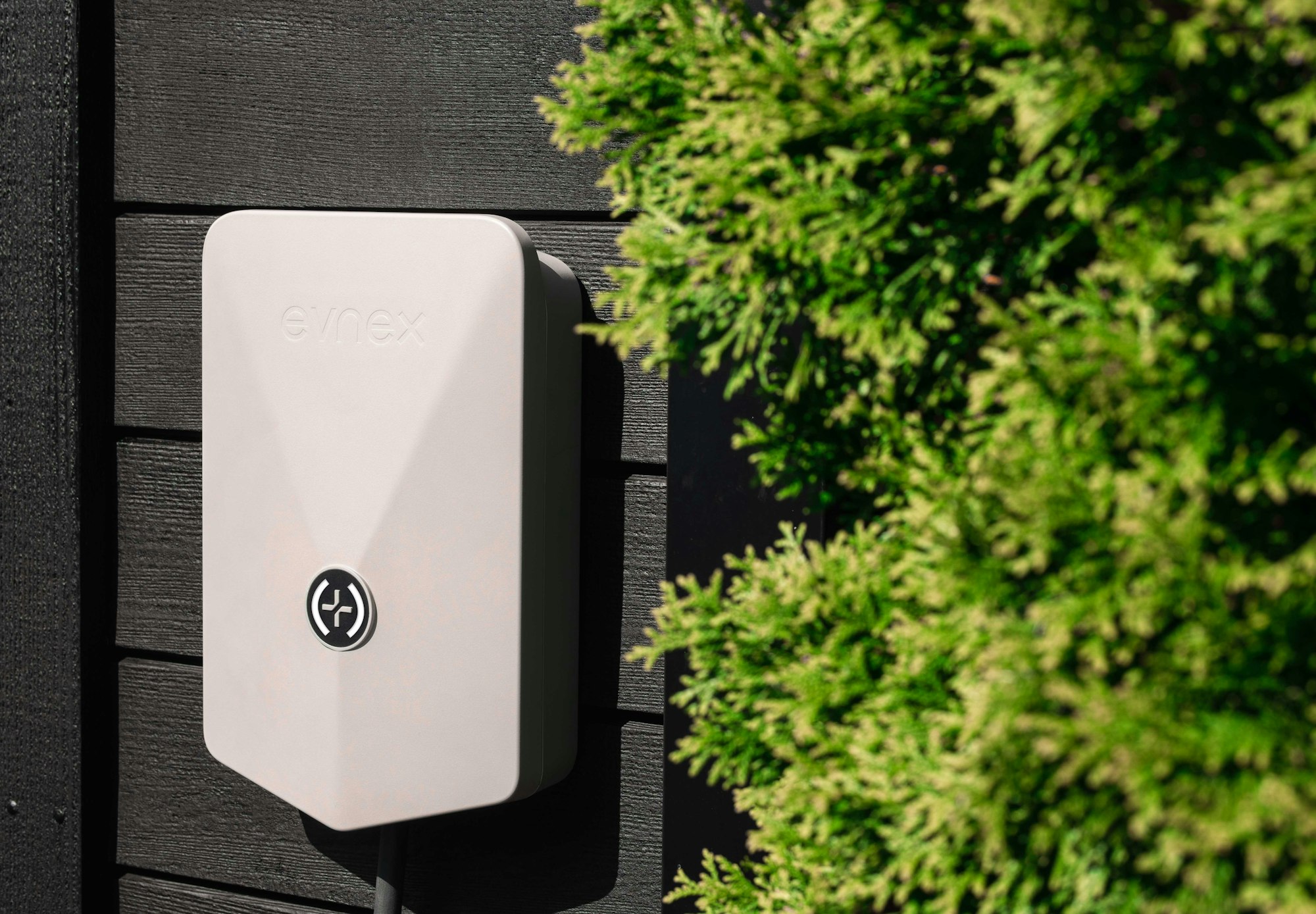 Wall-mounted EV charging unit beside a garage door