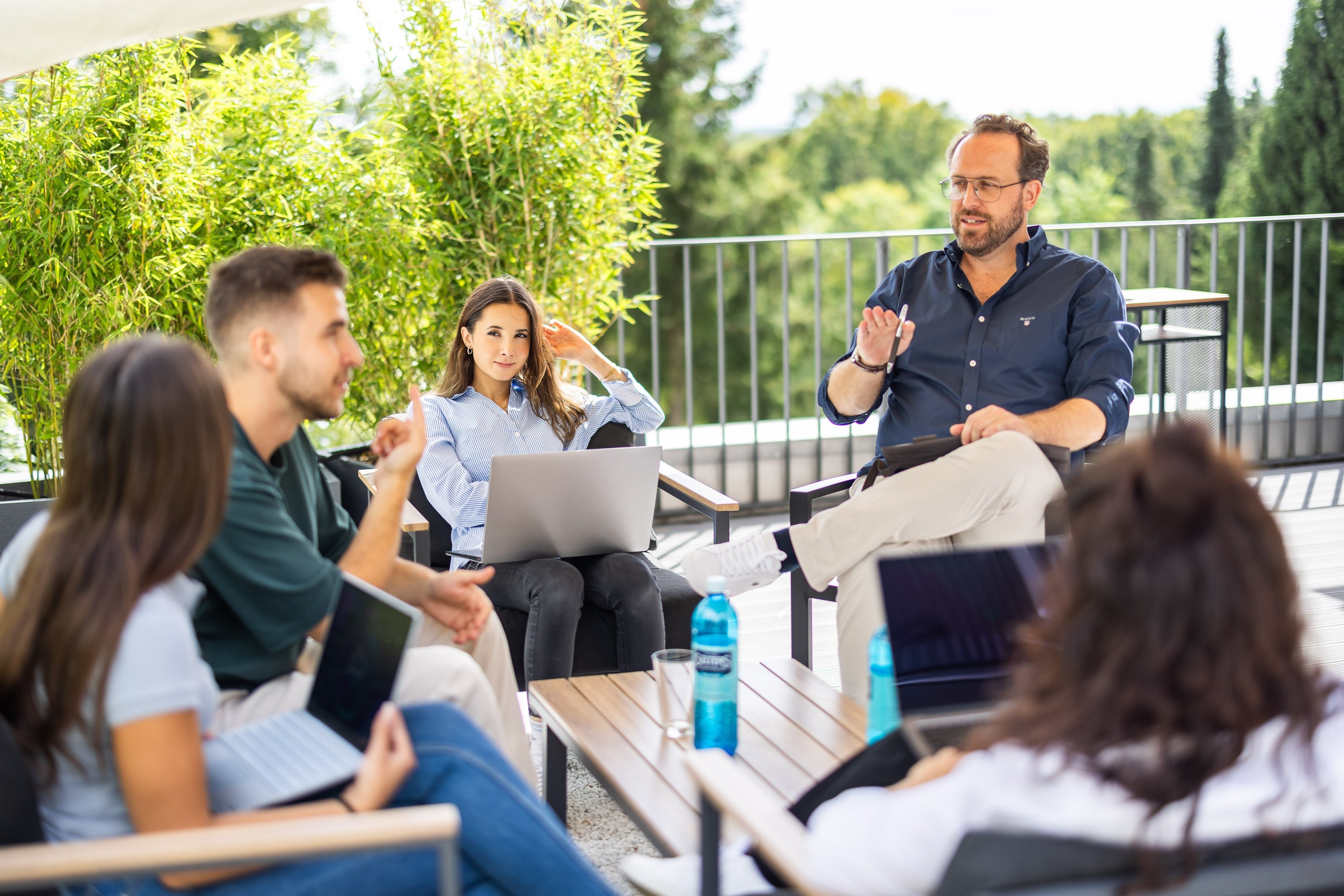 Das Team der Good News Company bei einer Besprechung auf der Büroterrasse in Dachau