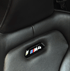 Schwarzer BMW M4 Ledersitz mit perforiertem Bereich und M4-Logo.