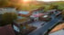 Luftaufnahme des Gewerbehofs von Schulz GmbH & Co.KG. mit begrünten Flachdächern und Holzfassaden vor hügeliger Landschaft im Sonnenuntergang.