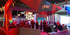 Messestand von Vizrt mit mehreren Personen, die an Tischen stehen und sitzen.