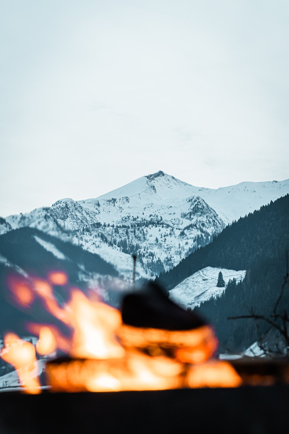 Lagerfeuer vor verschneitem Berg