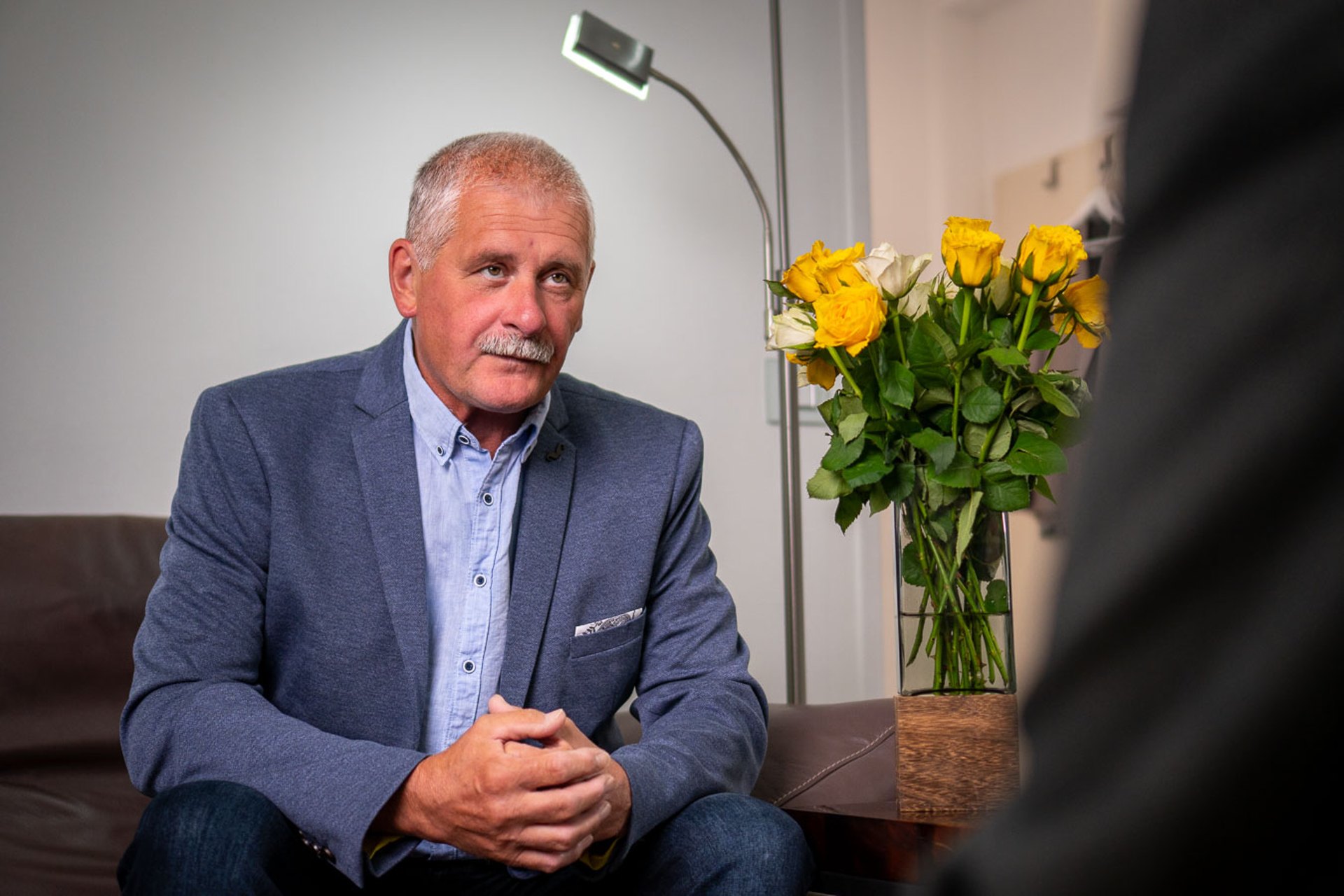 Ein Patient sitzt im Therapieraum und hört aufmerksam zu