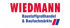 Wiedmann logo mit rotem Schriftzug, darunter blauer Text "Baustoffhandel & Abbruch" und ein rot-blauer Balken.