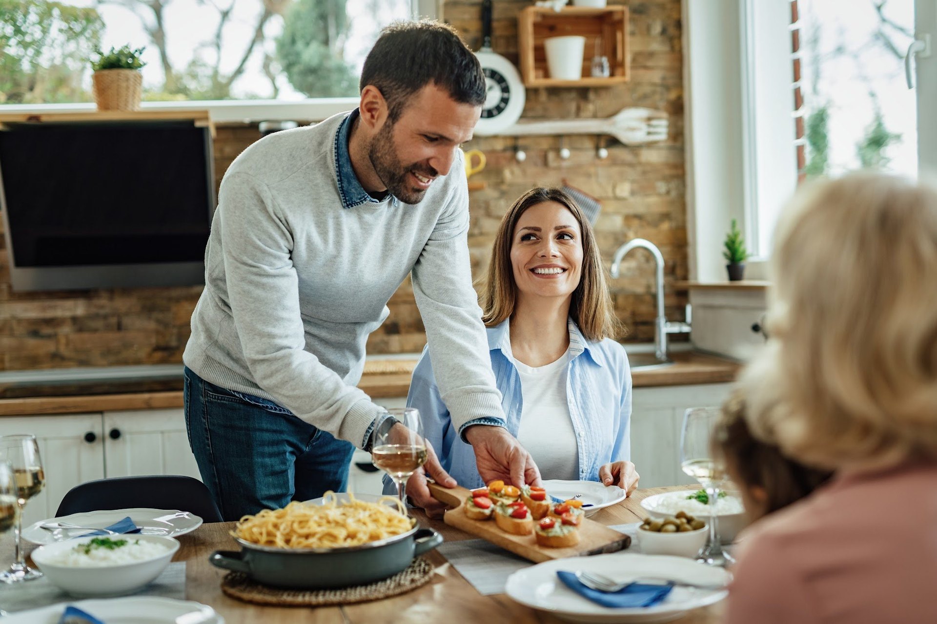 Familie genießt gemeinsam ein Mittagessen am Esstisch