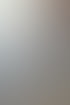 Person schneidet mit einer orangefarbenen Trennscheibe durch einen grauen Betonblock, wobei Staub entsteht.