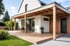 Moderne Terrasse mit schwarzer Pergola, Glasdach, weißen Wänden, Schiebetüren und Garten mit Hecke.