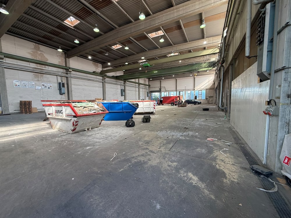 Große Gewerbehalle während der Räumung mit Containern