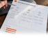 Eine Hand zeigt mit einem Stift auf ein Dokument mit dem Titel Automation Roadmap, das drei Phasen und Top-Prioritäten zeigt.