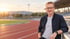 Fredy Infanger sitzt am Rand einer Laufbahn und beobachtet das Training