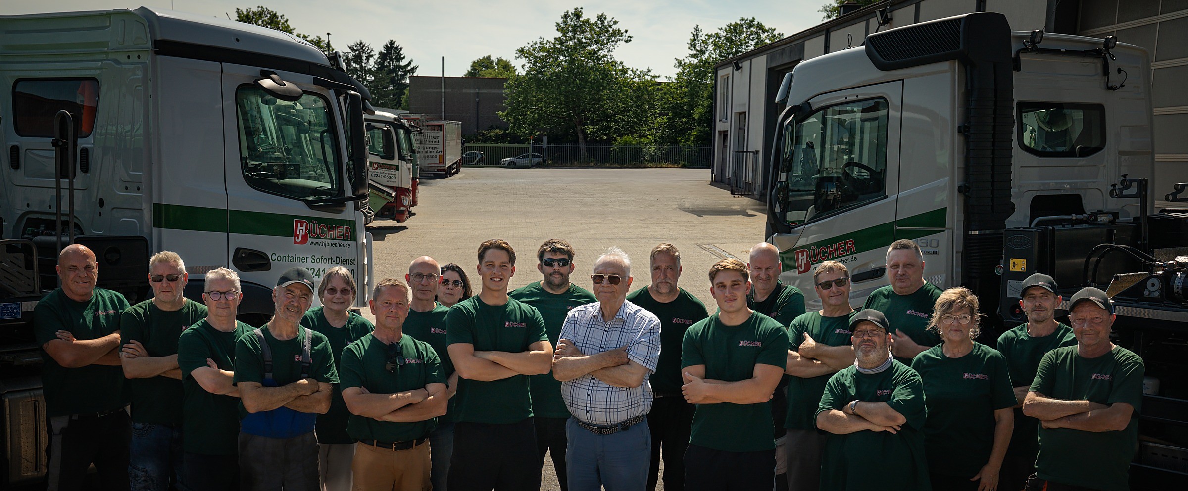 Das Team des Bücher Containerdienst vor dem Fuhrpark