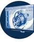 Ein Computermonitor zeigt eine blaue 3D-CAD-Modellansicht eines komplexen Zahnradmechanismus.