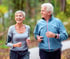 Senior couple jogging outdoors after benefitting from holistic cancer support.