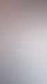 Eine Kosmetikerin in weißem Kittel und blauen Handschuhen massiert das Gesicht einer Kundin, die auf einer weißen Decke liegt.