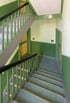 Grüne Treppe mit gelben und grünen Wänden in einem Flur.