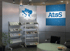 Atos-Büro mit Karte Südosteuropas, Atos-Logo, zwei Broschürenregalen und rundem Tisch mit Stühlen.