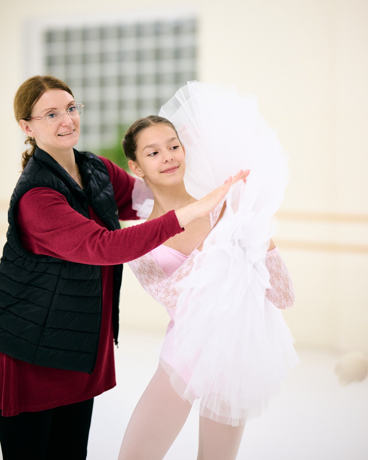 Nina and Adélie smile as they prepare a pose with a white tutu.