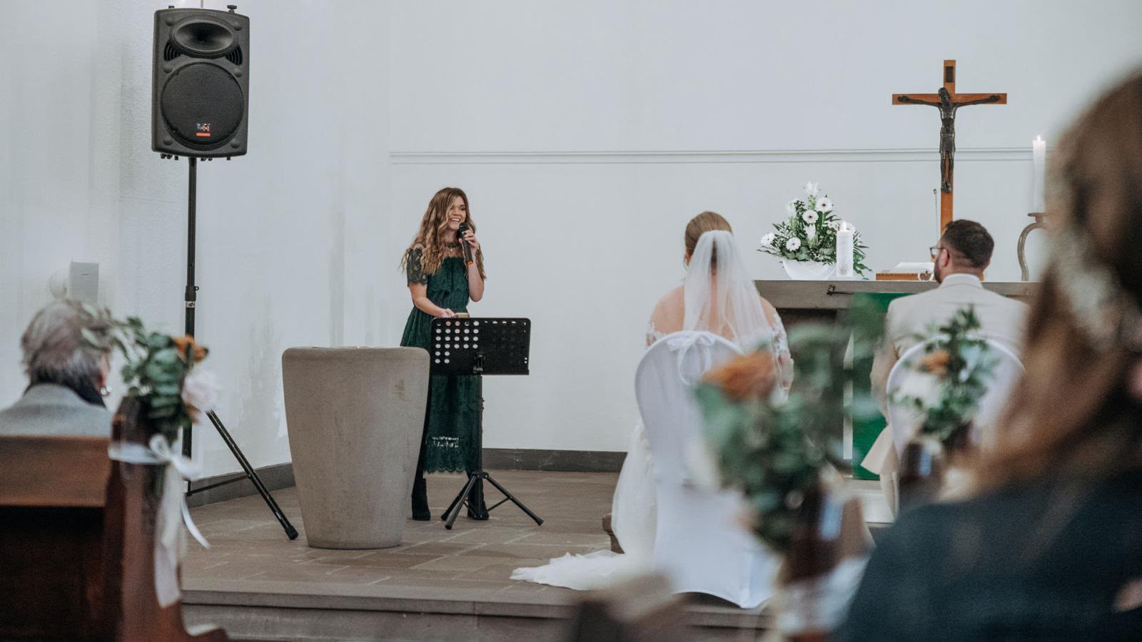 Rebekka singt in der Kirche, das Brautpaar sitzt vor dem Altar
