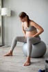 Pregnant woman sitting on exercise ball holding belly