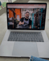 Ein MacBook Pro zeigt einen lächelnden Mann in Arbeitskleidung, der in einer Werkstatt den Daumen hochhält.