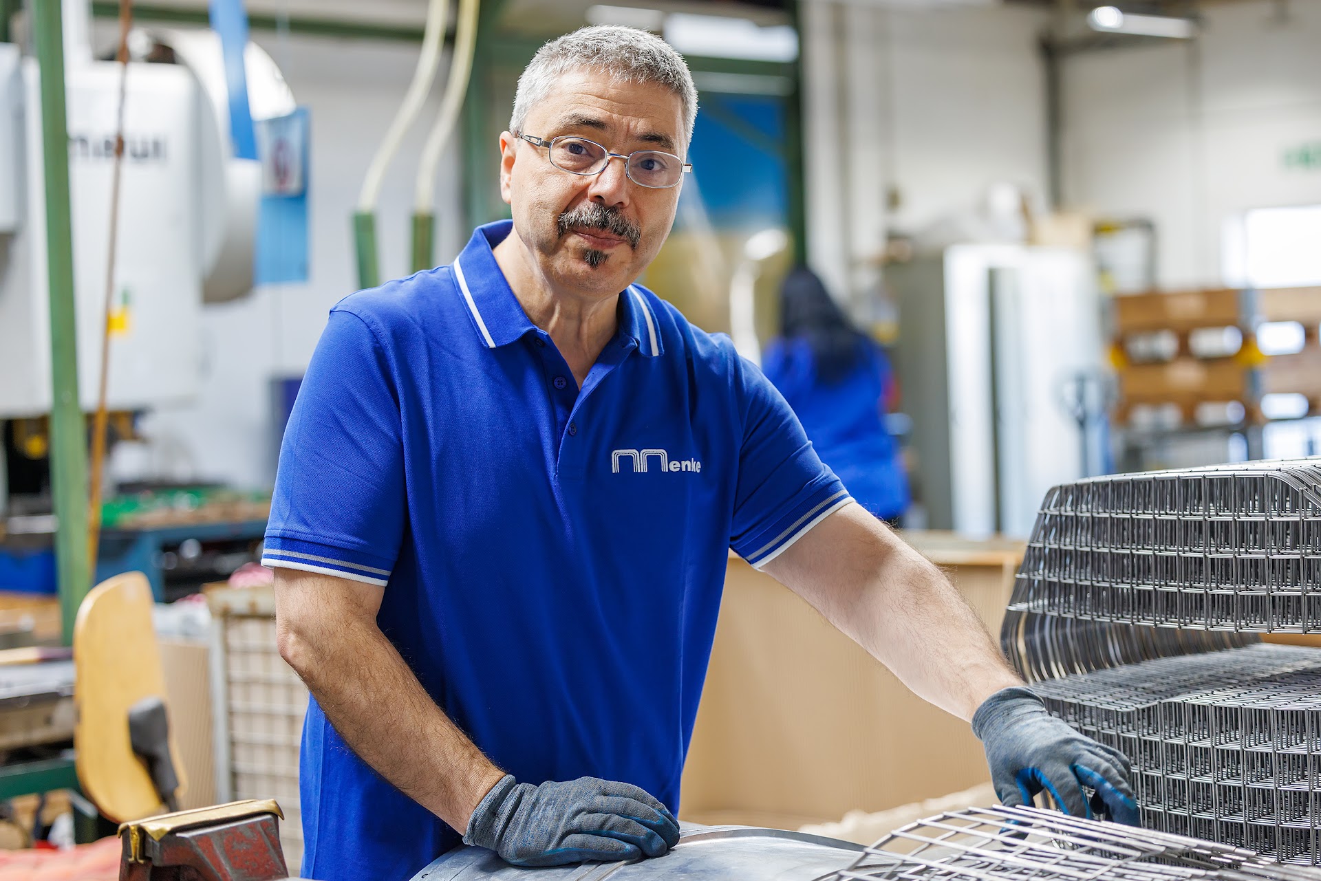 Mitarbeiter der Menke GmbH mit einem Drahtgitterteil in der Fertigung in Neuenrade