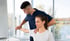 Physical therapist helps a woman exercise at a bright wellness center.