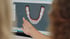 Digitale 3D-Darstellung eines Kiefermodells mit Zähnen auf einem Computerbildschirm, auf das eine Hand zeigt.