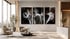 Drei abstrakte Schwarz-Weiß-Kunstwerke mit Lichtstreifen hängen über zwei hellen Sesseln in einem modernen Wohnzimmer.