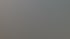 Weißer Schreibtisch und Stuhl vor einem Fenster mit Blick auf eine blasse Skyline und Berge.