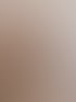 Eine Frau mit kurzem, gestuftem, rotbraunem Haar sitzt im Profil; sie trägt eine beige Strickjacke.