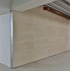Eine beige Wand mit einer roten Rohrleitung darüber und einem silbernen Eckschutz.